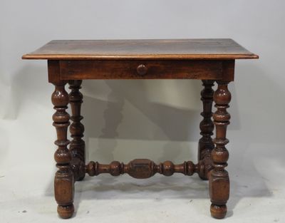 une vieille table en bois avec un tiroir en dessous, posée sur un plan de travail blanc