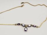 a close up of a gold chain bracelet with purple beads