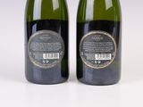 two bottles of wine sitting next to each other on a white surface