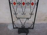a black iron fence with red balls on it