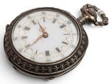 a pocket watch with roman numerals on the face
