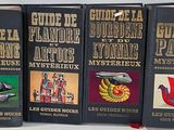 trois livres posés sur une table blanche, avec une rose rouge devant eux