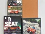 trois livres posés sur un fond blanc, avec une voiture de sport rouge en couverture
