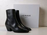 the black leather ankle boots are next to a white box