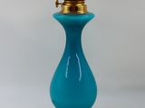 une lampe en verre bleu posée sur une table