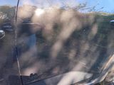 a close up of a car ' s door handle with a blurry image of a person in the background