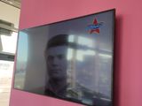 a flat screen tv mounted on the wall in a pink room
