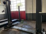 une photo d'un garage avec une voiture au milieu