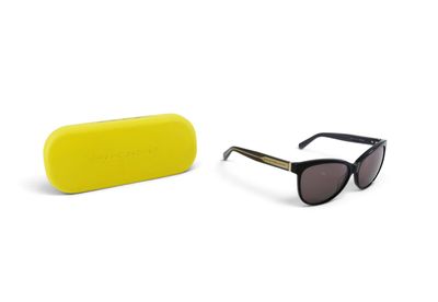 une paire de lunettes de soleil et un étui jaune posés sur une surface blanche