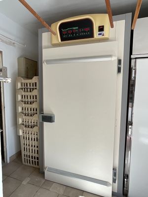 une photo d'un réfrigérateur dans une cuisine, avec une horloge sur la porte