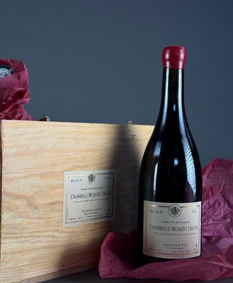 une bouteille de vin posée à côté d'une caisse en bois