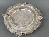 an antique silver plate with a decorative design on the rim