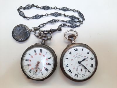 deux montres de poche posées sur une table