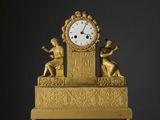 une horloge en or posée sur une table blanche