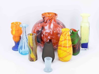de nombreux vases de différentes couleurs posés sur une surface blanche