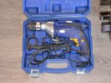 une mallette à outils bleue contenant des outils, posée sur un plancher en bois