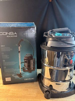 une photo d'un aspirateur posé sur une table, à côté d'une boîte
