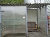a metal structure with a bench in front of it