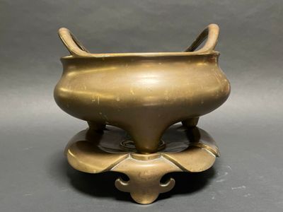 an old bronze incense pot with two horns on top of it