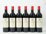 six bouteilles de vin rouge alignées sur une surface blanche