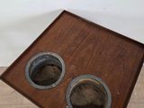 a small wooden table with two round holes in it