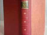 an old red book sitting on top of a white table