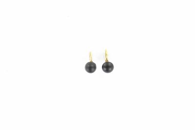 une paire de boucles d'oreilles avec des perles noires sur fond blanc