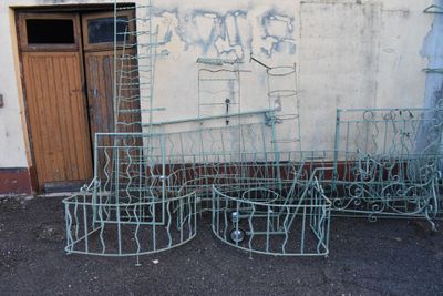 a lot of old metal furniture outside of a building