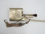 a small metal pipe with a handle and a tassel on it