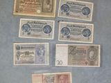 Plusieurs anciens billets de banque allemands sont exposés dans une vitrine.