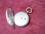 a small silver pocket watch on a red cloth