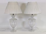 pair of clear glass lamps with plea lampshads on a white surface