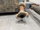 a rusted pipe on the floor next to a metal container