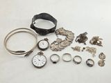 a lot of silver jewelry on a white surface