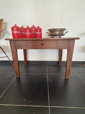 une table en bois sur laquelle sont posées des bouteilles rouges