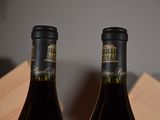two bottles of wine that are sitting on a table