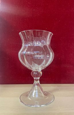 a glass vase sitting on a table with a red wall in the background
