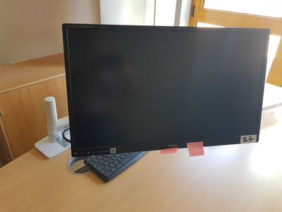 a computer monitor sitting on top of a wooden desk