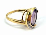 an image of a gold ring with a purple stone and diamonds