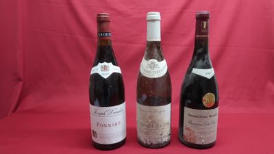 three bottles of wine are lined up on a red background