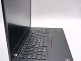 the laptop is open on a white surface with a red button on the keyboard