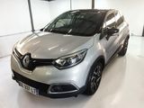 La voiture argentée est garée dans une grande pièce au sol blanc.