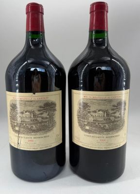 two bottles of red wine sitting next to each other on a table