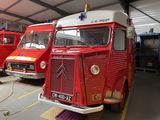 trois camions de pompiers rouges garés dans un garage