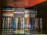a lot of dvds stacked on a glass shelf