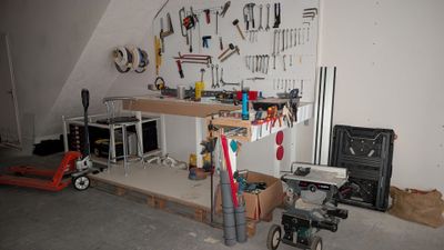 a workbench in a garage with tools on the wall