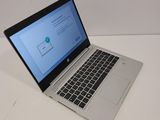 the laptop is open on a white table with a blue screen