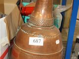 a large copper pot sitting on the floor next to a box