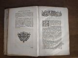 a book open on a wooden table with a picture of a coat of arms
