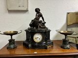 une horloge posée sur une table en bois à côté d'un miroir